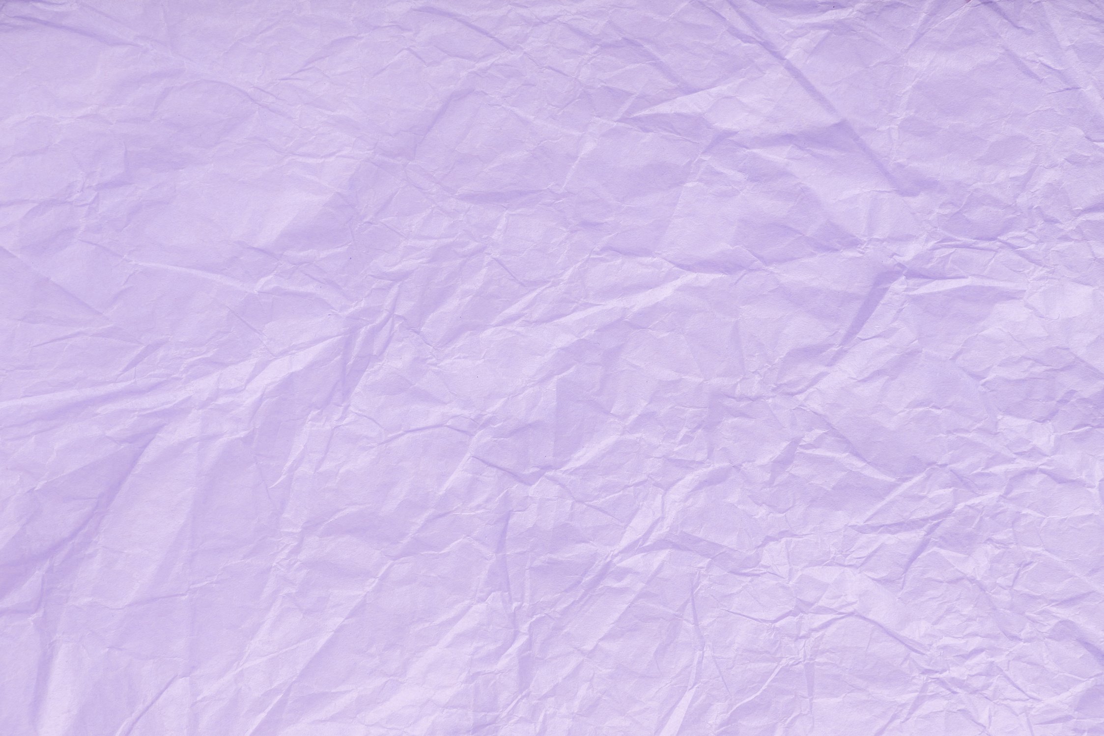 Texture of crumpled violet wrapping paper, closeup. Lilac old background.